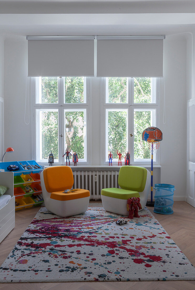 Easy chairs on rug with pattern of multi-coloured splashes in child's bedroom