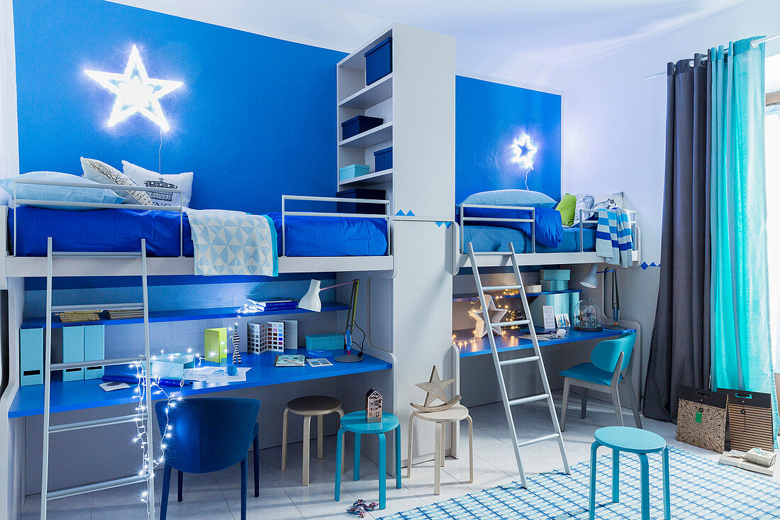 Weihnachtlich dekoriertes blaues Geschwisterzimmer mit Schreibtischen unter Hochbetten