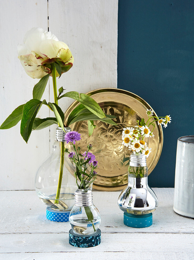 Vases made from old light bulbs in stands made from rolls of washi tape