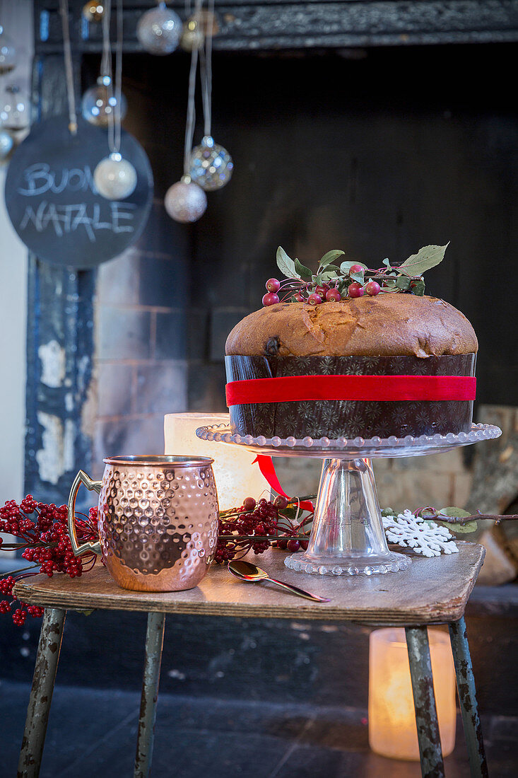 Panettone auf Tisch vor weihnachtlich dekoriertem Kamin