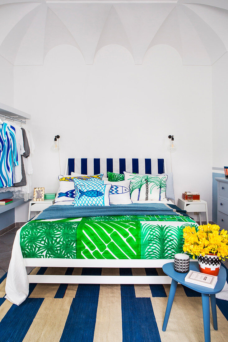 Schlafzimmer mit Textilien im blau-grünen Mustermix