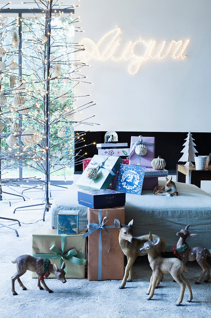 Verpackte Weihnachtsgeschenke dekoriert mit Rehfiguren und Kugeln