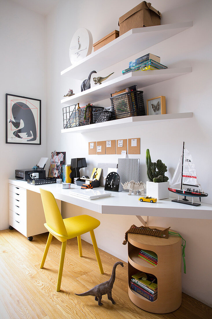 Weiße Schreibtischplatte, darüber weiße Regale und gelber Stuhl im Jugendzimmer