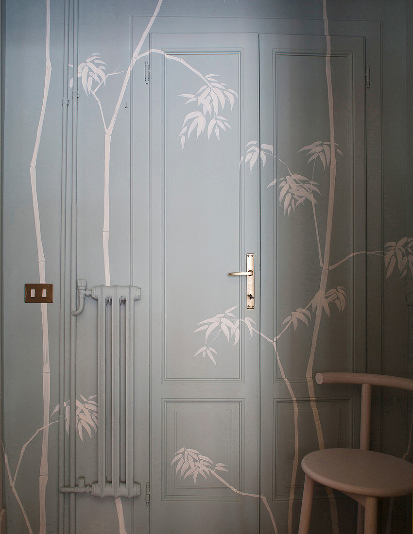 Tür, Wände und Heizung gestrichen in Grau und dekoriert mit Bambuszweigen in Schablonenmalerei