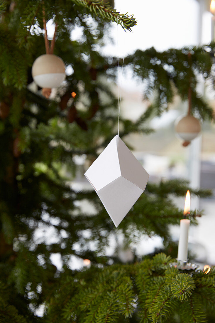 Christmas tree decorated with origami, wooden baubles and candles