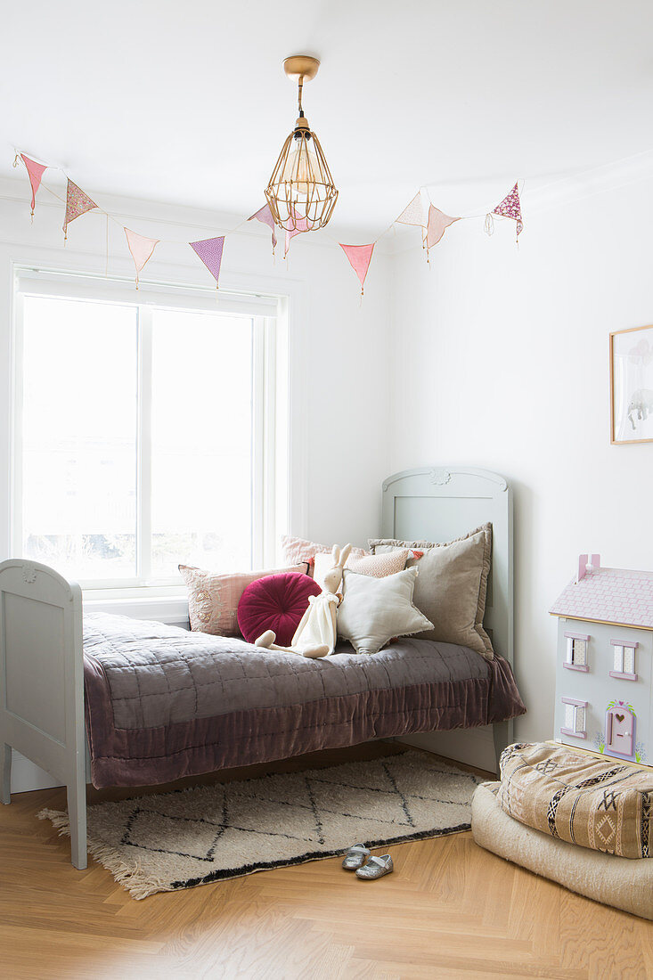 Old bed in vintage-style child's bedroom in muted shades