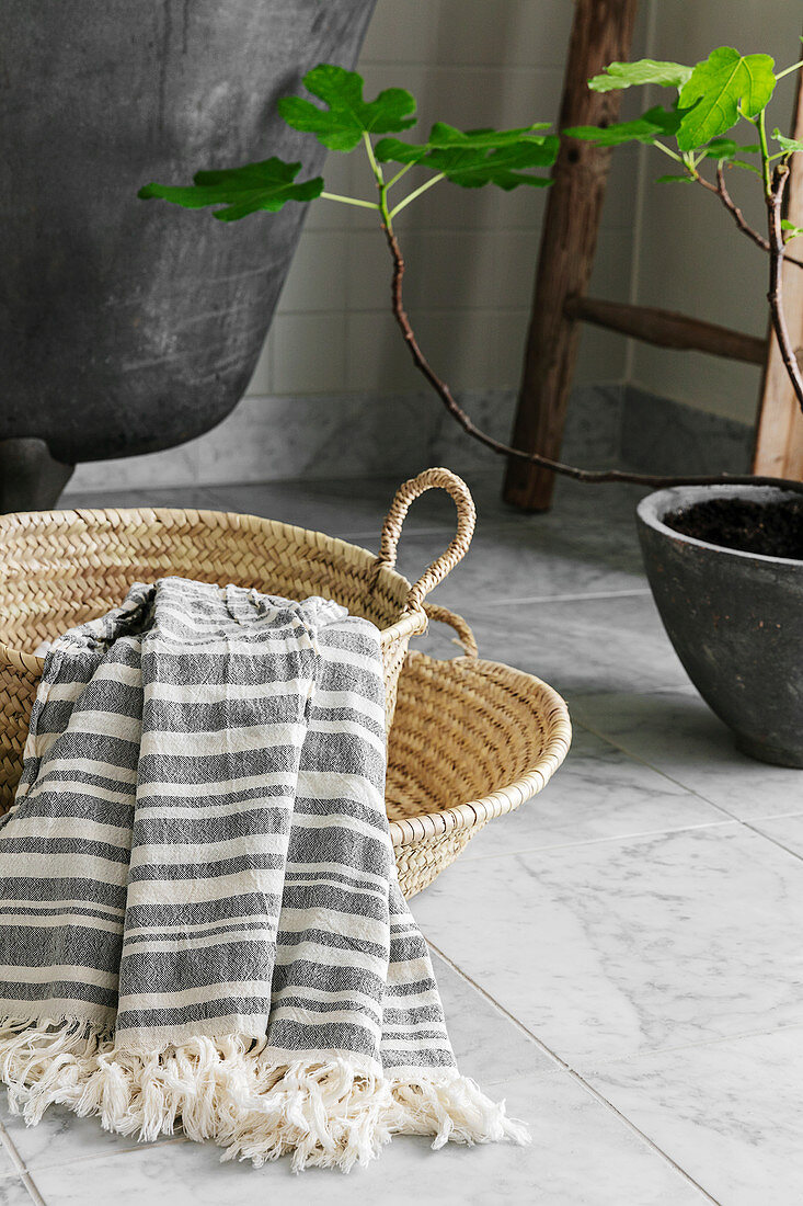 Gestreiftes Baumwoll-Handtuch in Körben vor der Badewanne