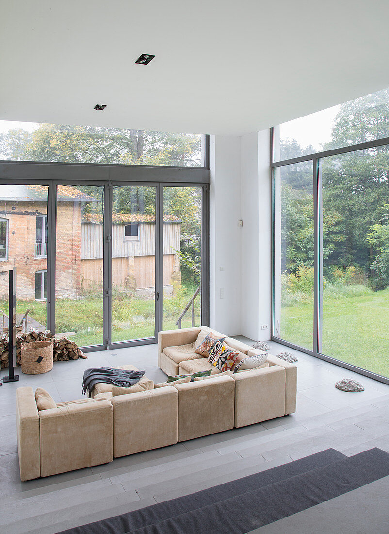 Beiges Sofa im modernen Wohnzimmer mit Fensterfront