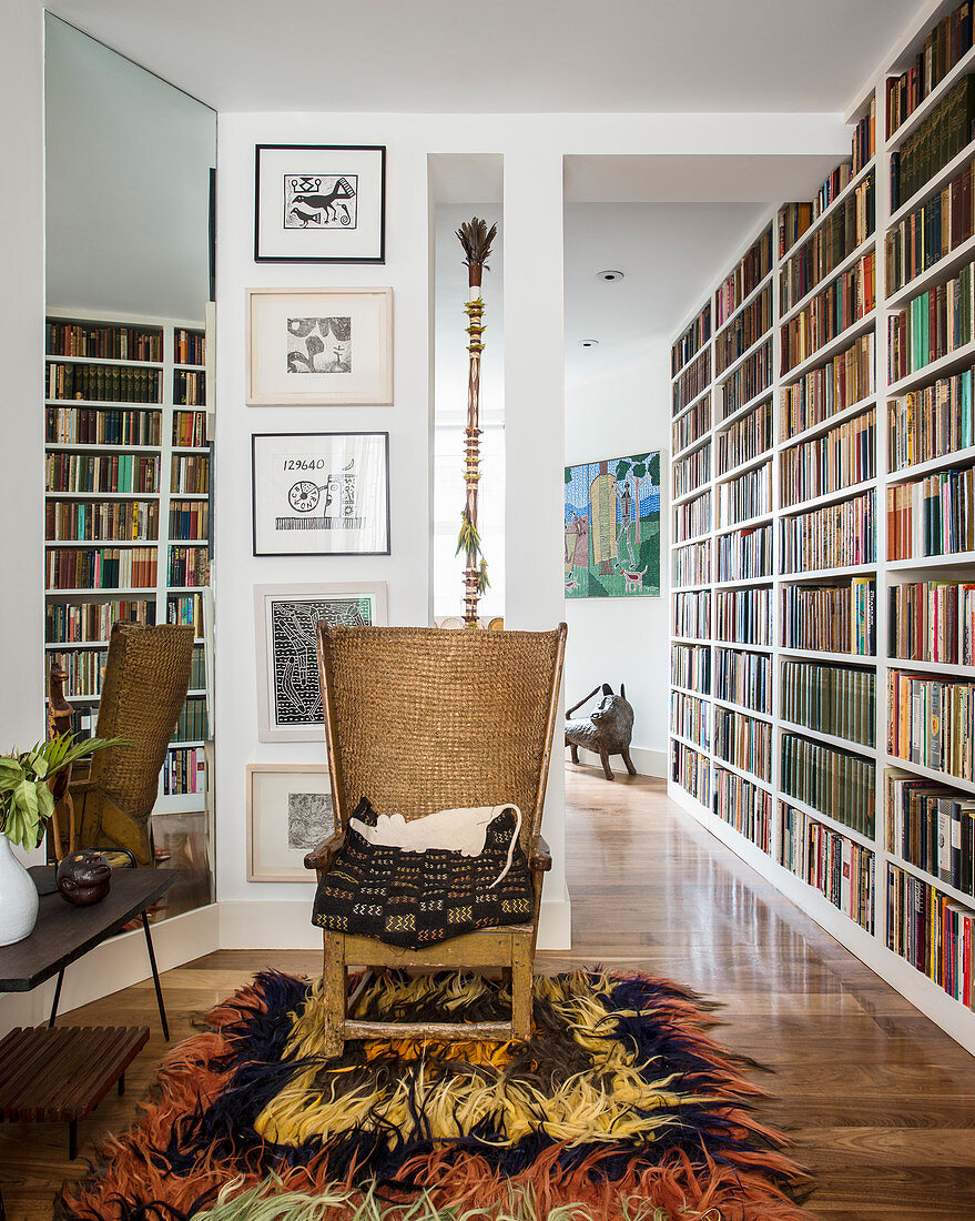 Sessel auf Hochflorteppich im Retrostil vorm Bücherregal
