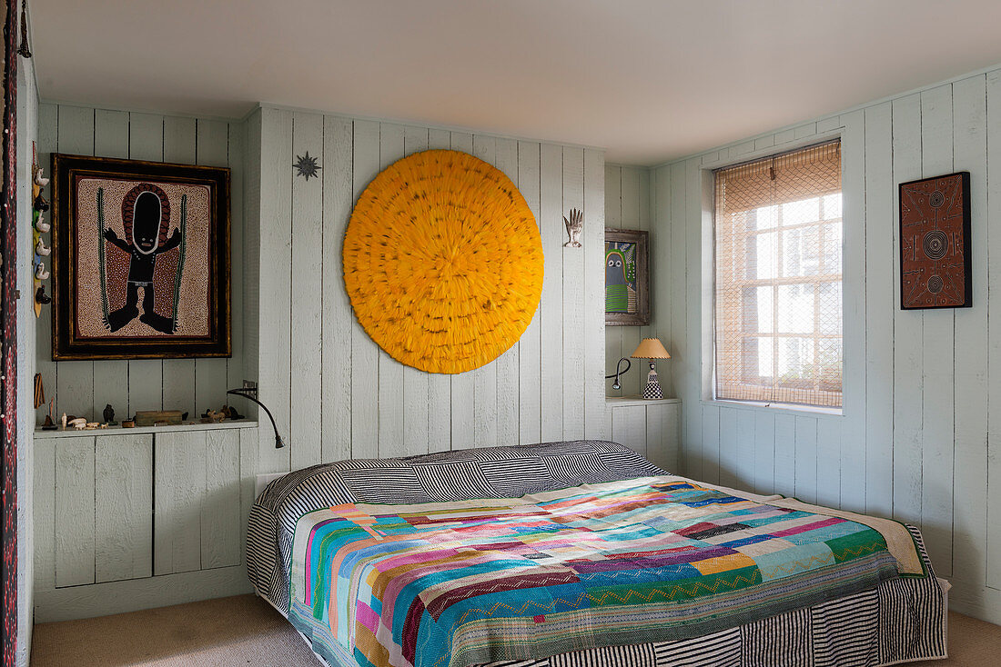Patchwork quilt on bed in wood-panelled bedroom