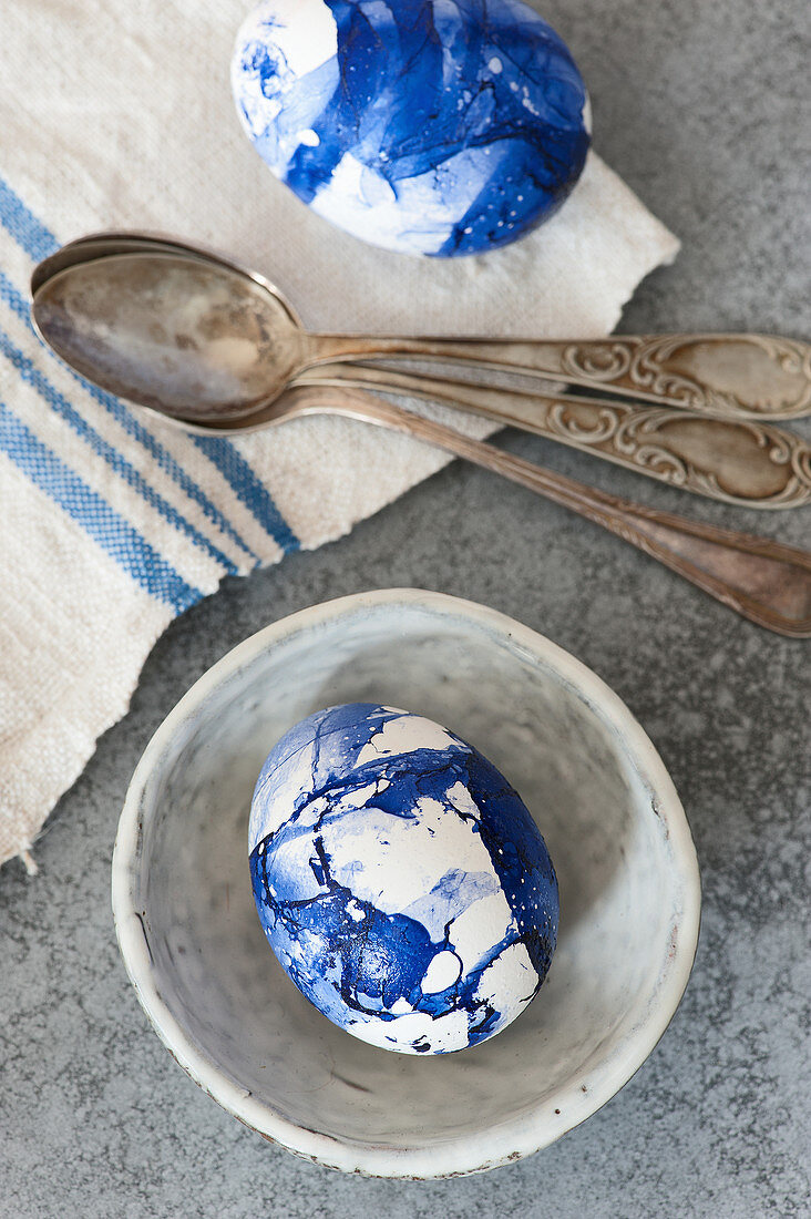 Blue marbled Easter eggs and vintage silver spoon