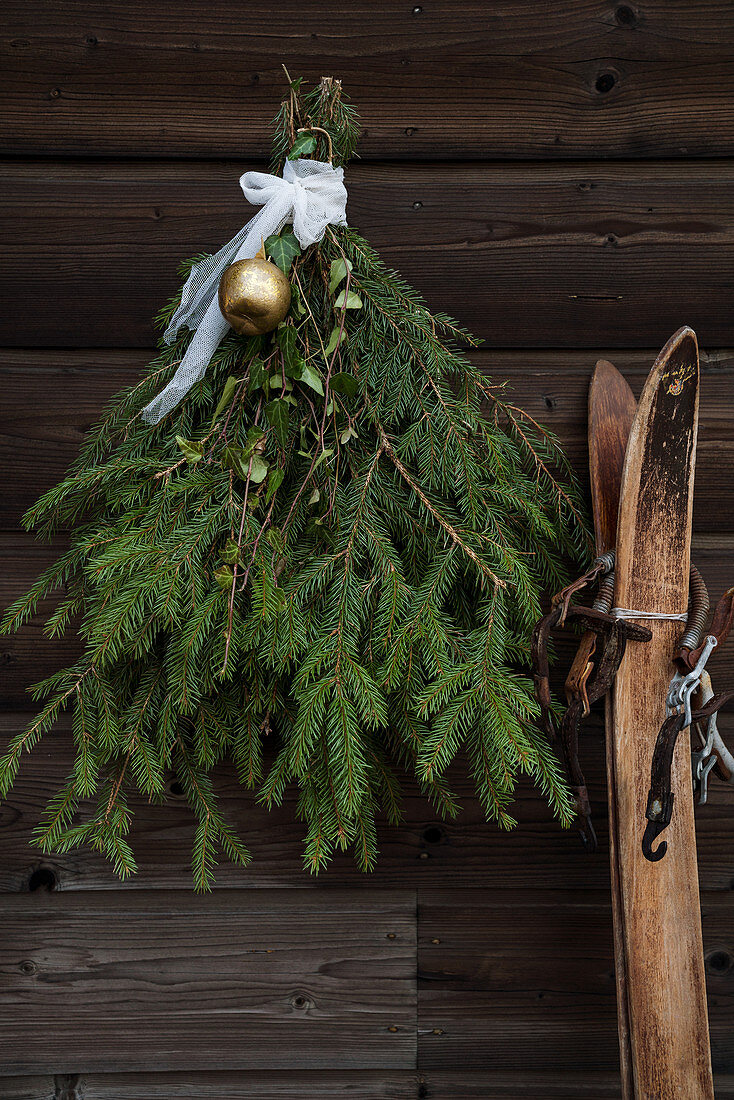 Christmas arrangement of spruce branches on rustic wooden wall