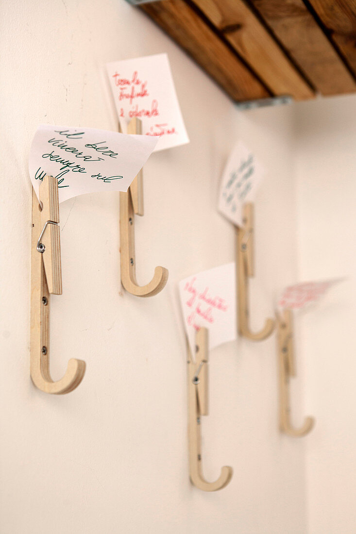 Coat pegs made from wooden clothes pegs holding positive mottoes