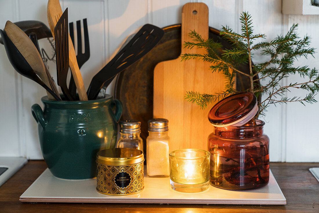 Kitchen utensils, candle lantern and conifer branch