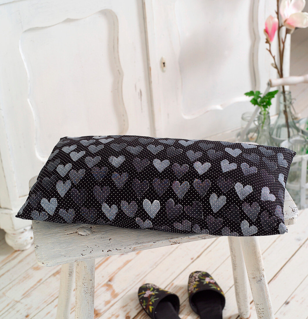 Black cushion with white polka-dots and stamped pattern of hearts