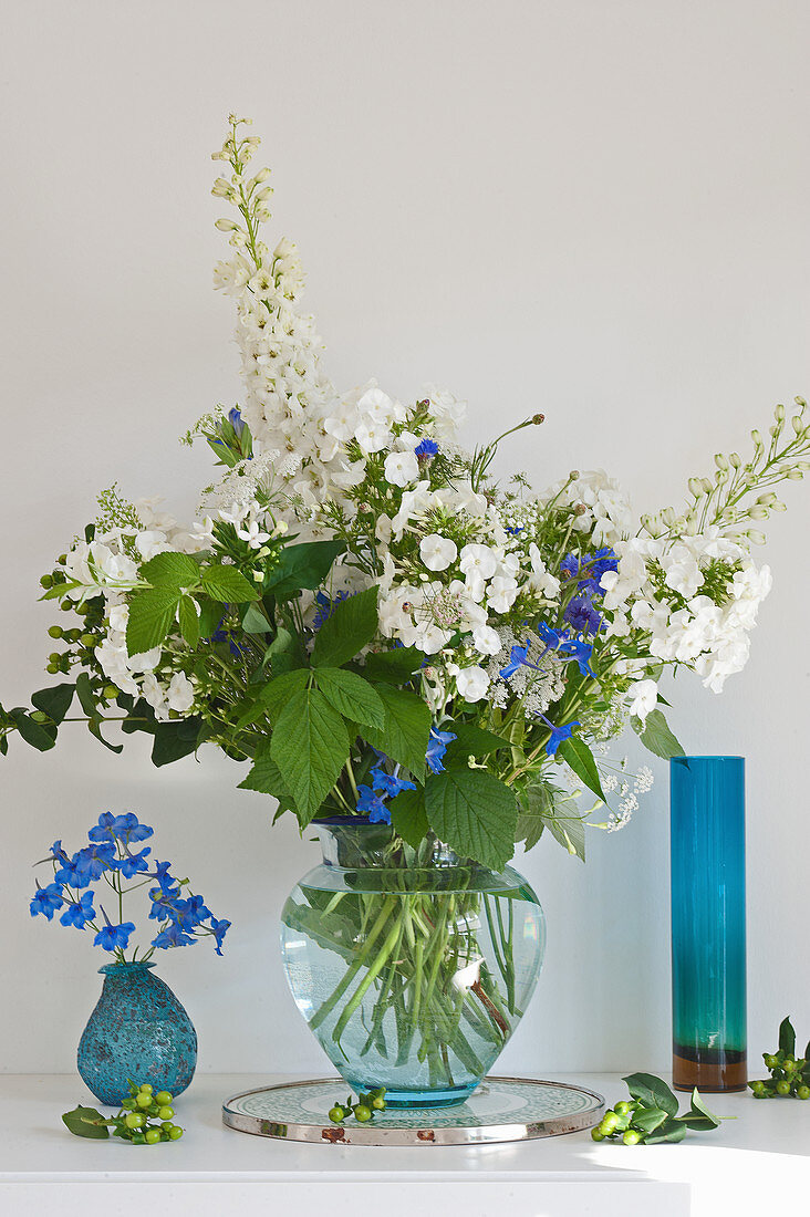 Üppiger Blumenstrauß in Blau und Weiß mit Phlox, Rittersporn und Himbeerzweigen