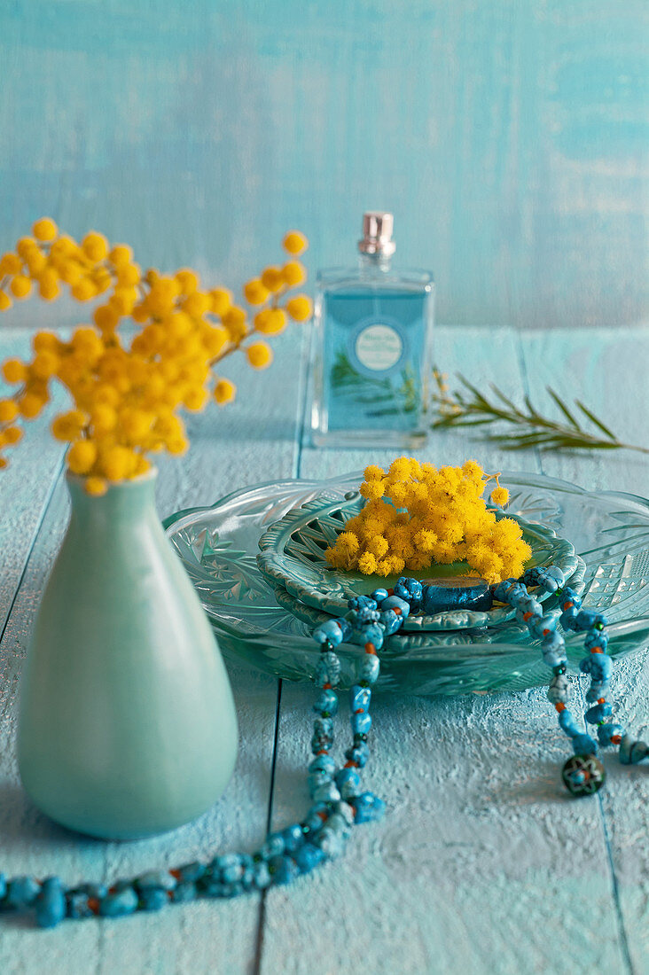 Glass plate, ceramics, turquoise necklace and mimosa flowers