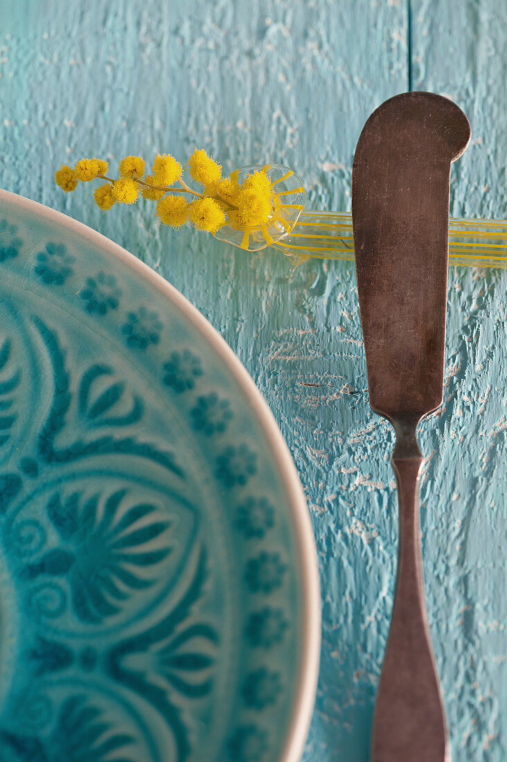 Kleine Vase mit Mimose als Messerbänkchen