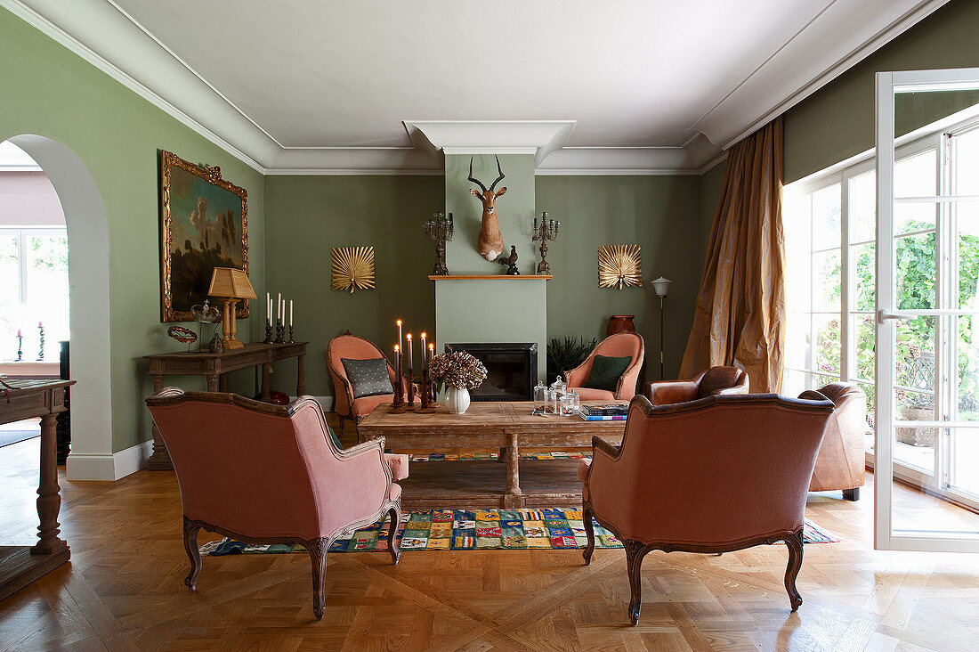 Baroque armchairs in classic living room with pale green walls