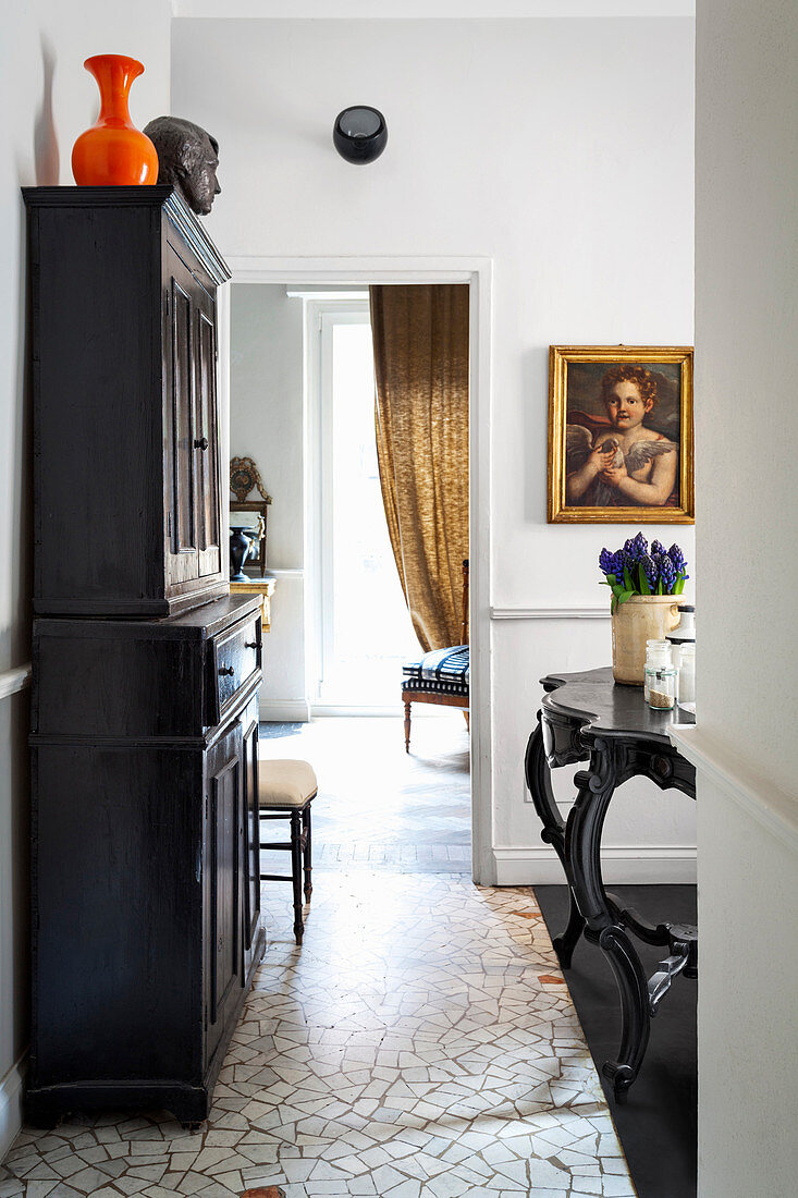 Black cabinet on mosaic-tiled floor in classic interior