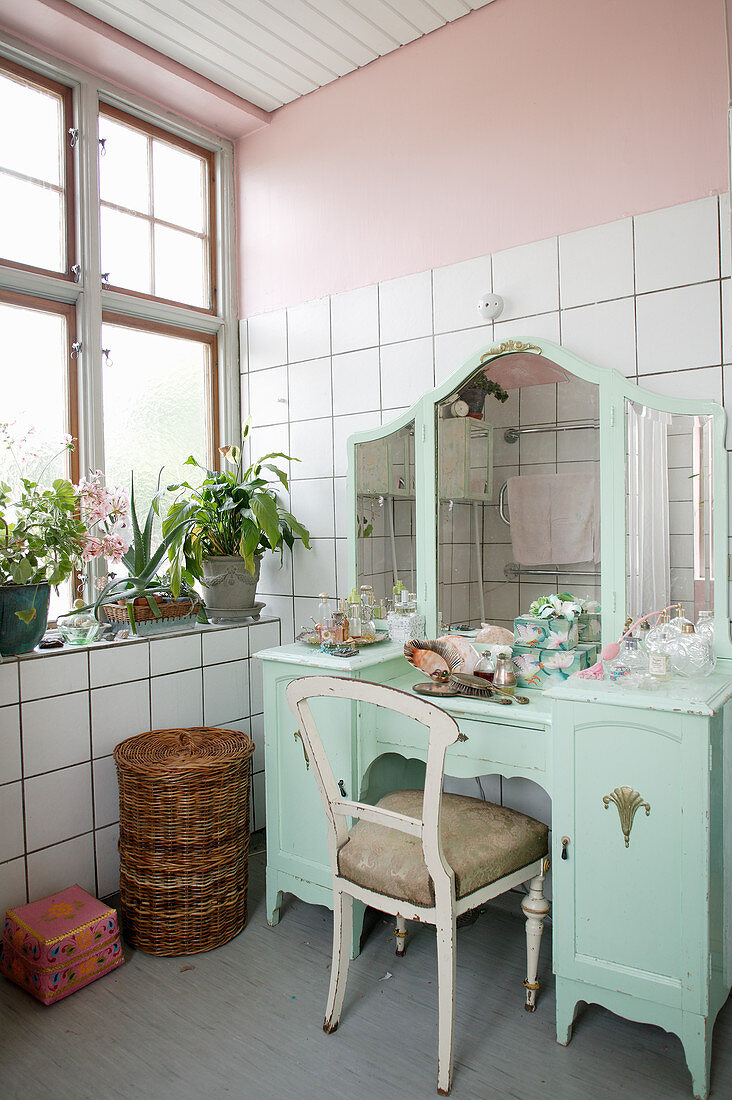 Antique, turquoise dressing table in bathroom with pink walls