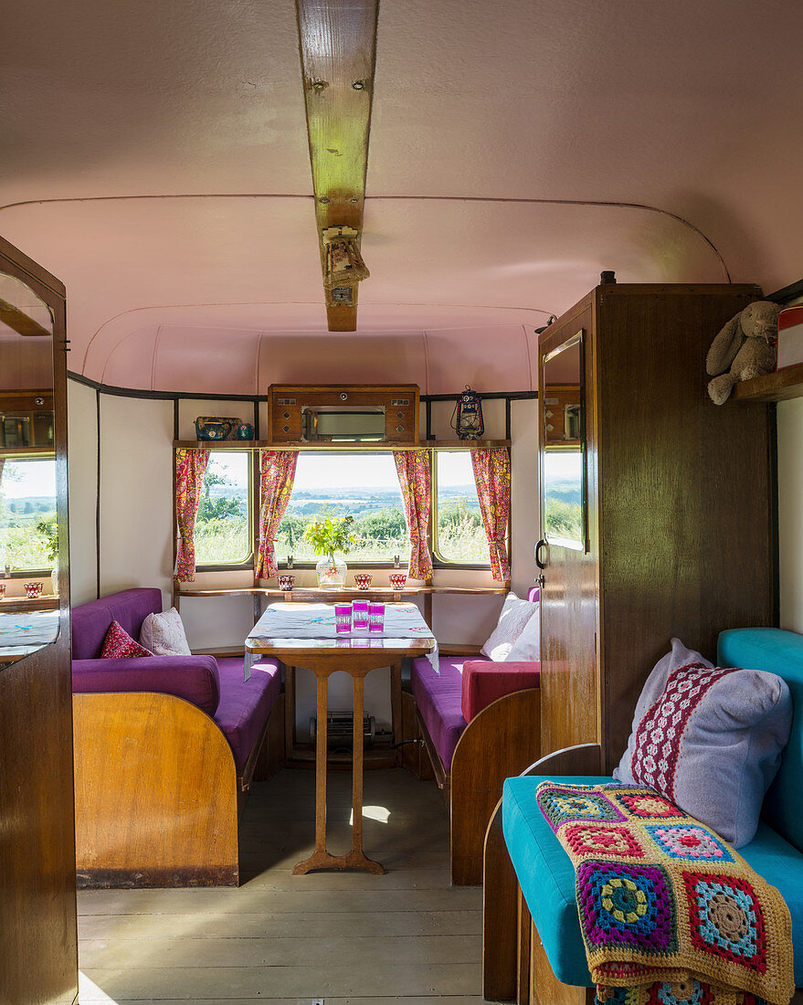 Wooden furnishings and colourful upholstery in old caravan