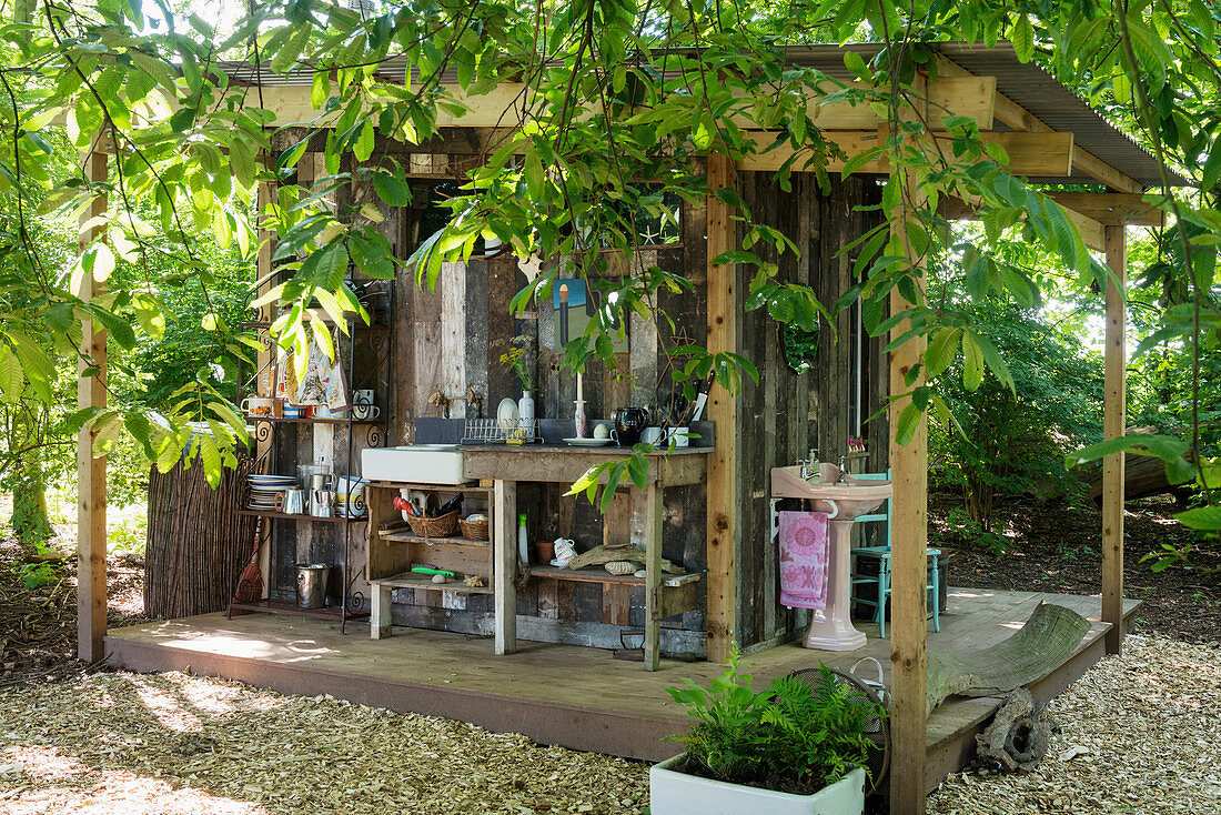 Outdoor kitchen and bathroom on façade of small wooden shed