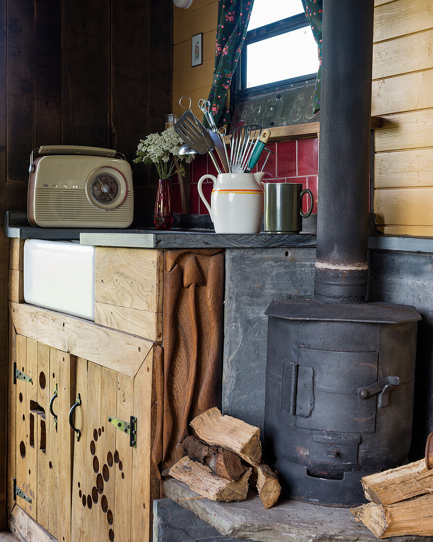 Holzofen neben der Spüle im rustikalen Tiny-Home