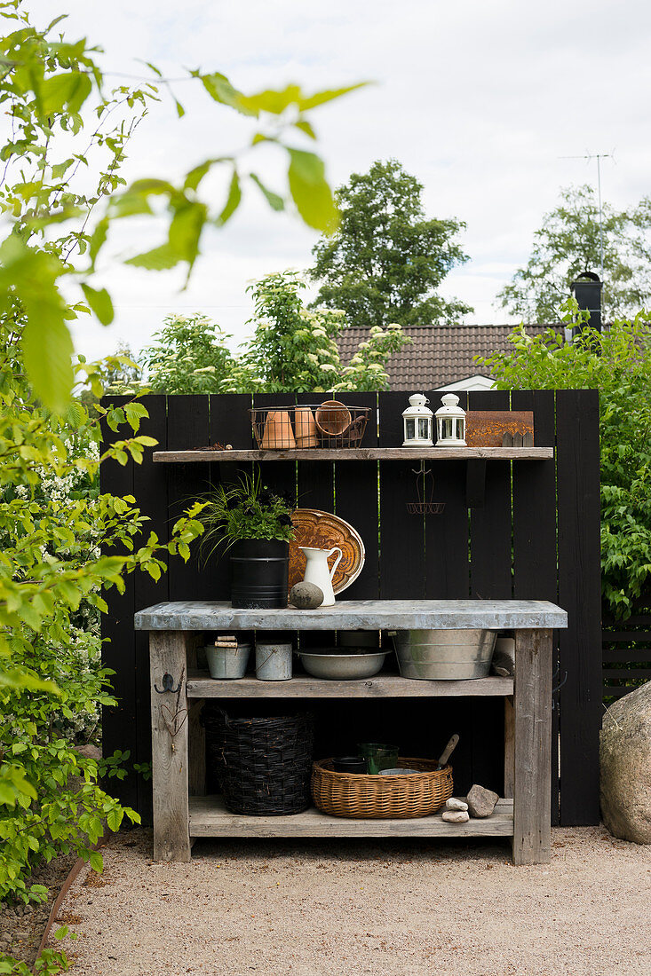 Rustic potting table against black board wall in garden