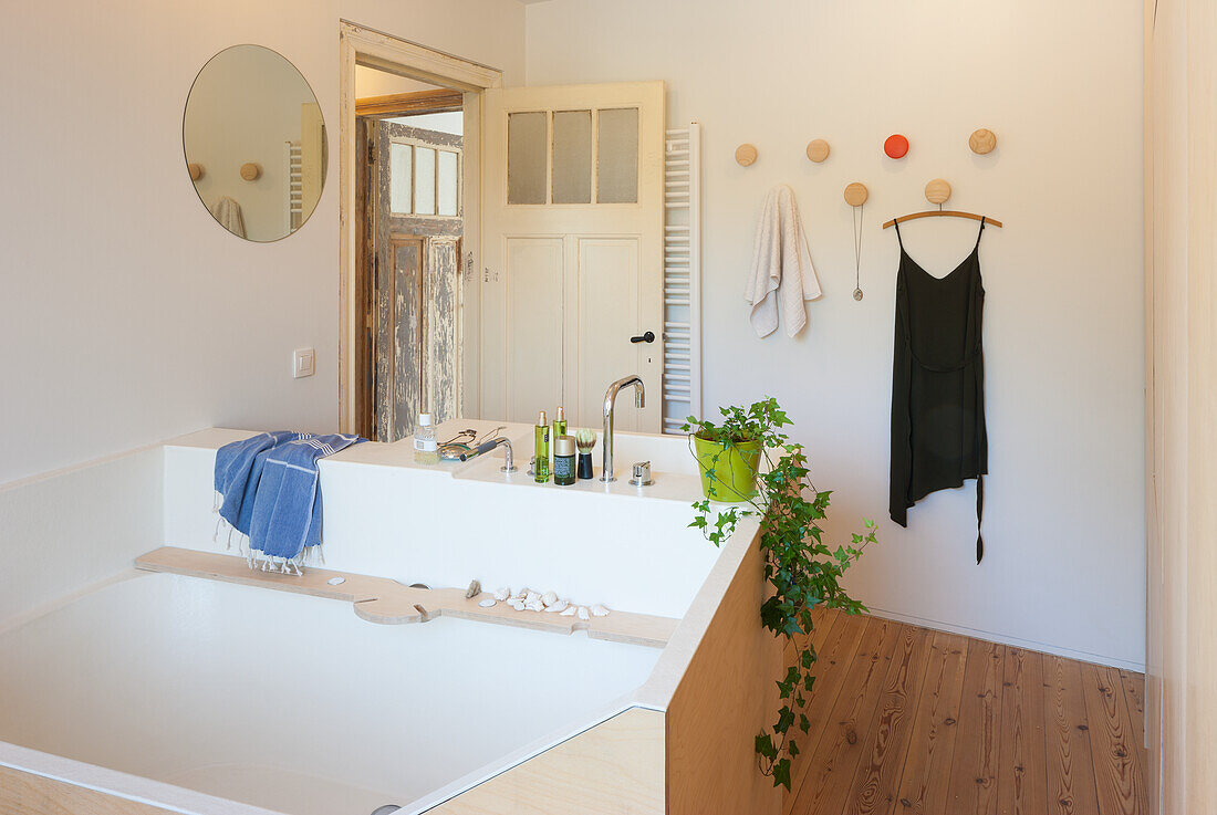 Minimalist bathroom with wooden floor and white walls