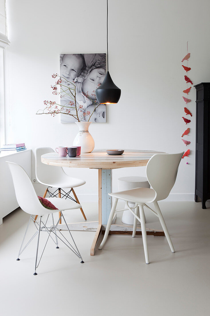 Various white chairs at round table made from reclaimed wood