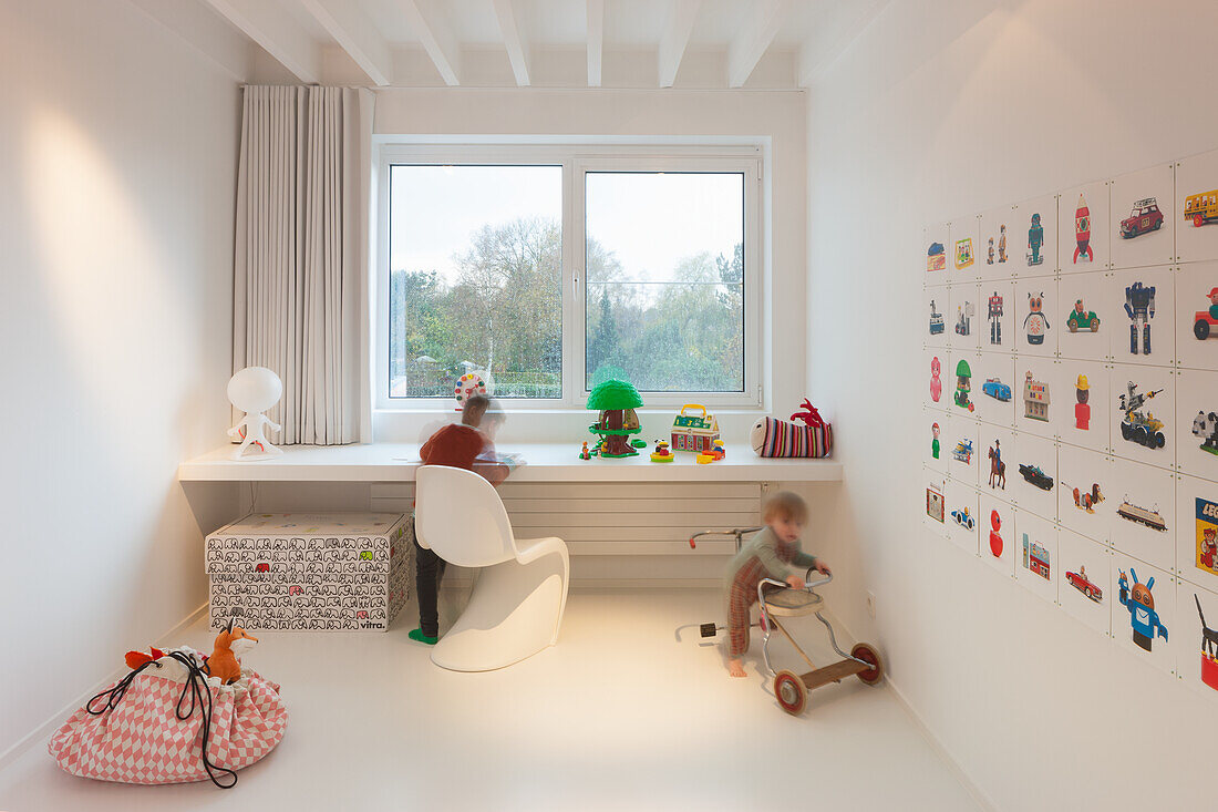 Hell gestaltetes Kinderzimmer mit Spielzeugecke und Wanddekoration