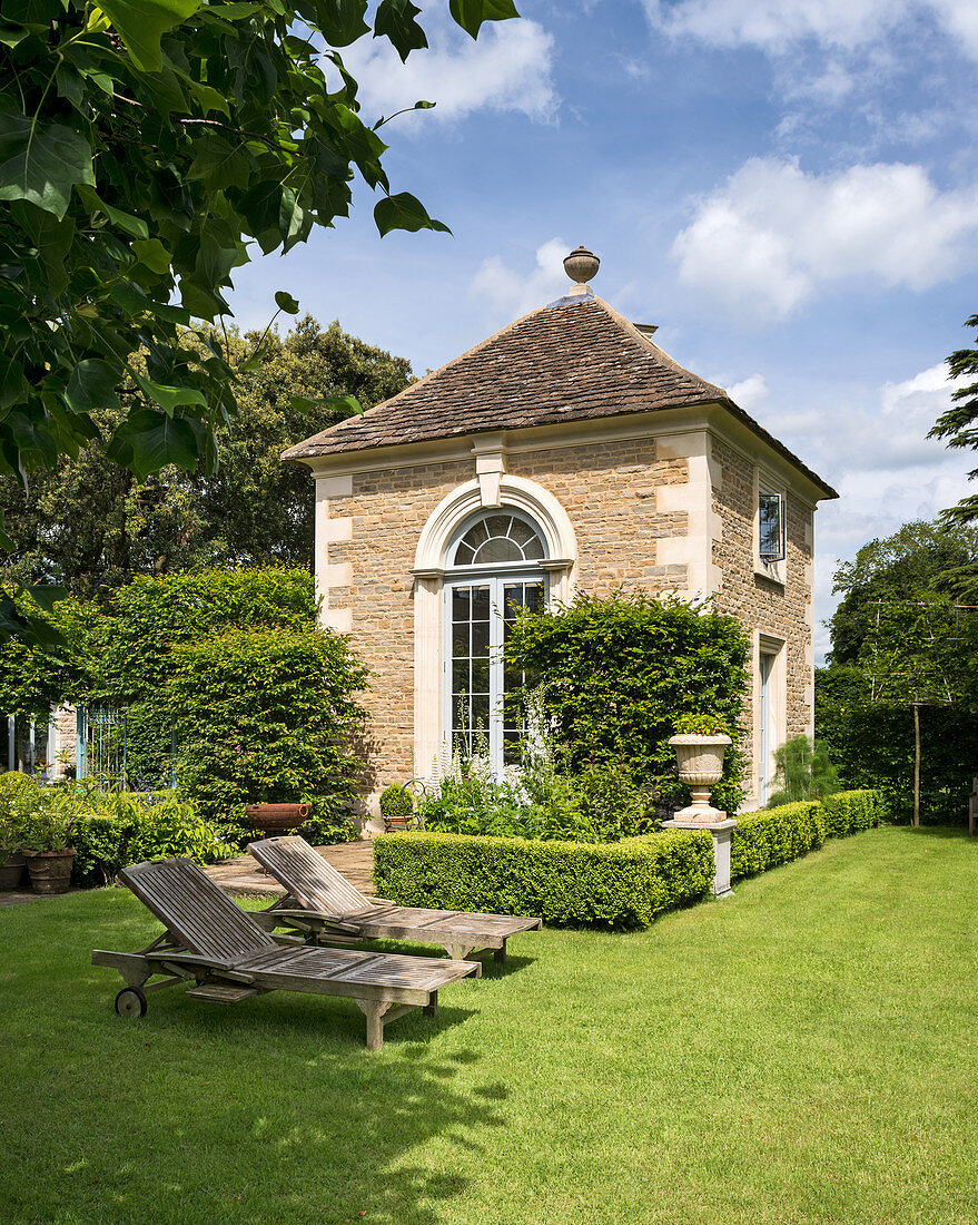 Historisches Steinhaus im sommerlichen Garten im Englischen Stil
