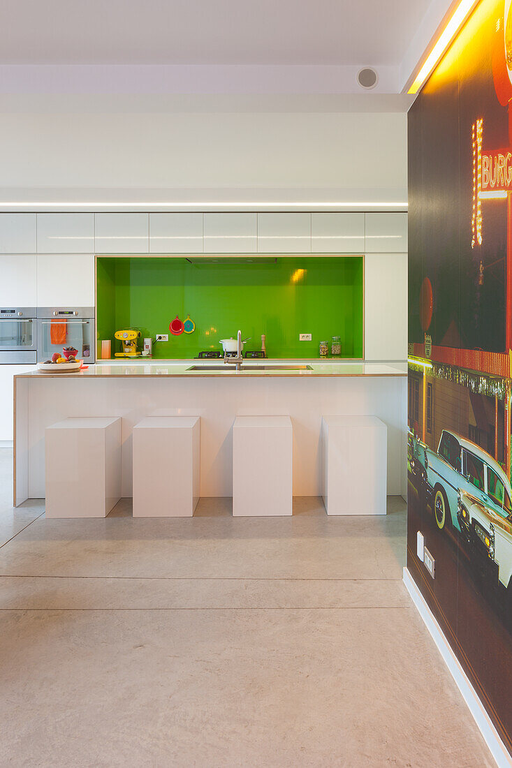 Modern kitchen unit with green back splash and white bar stools