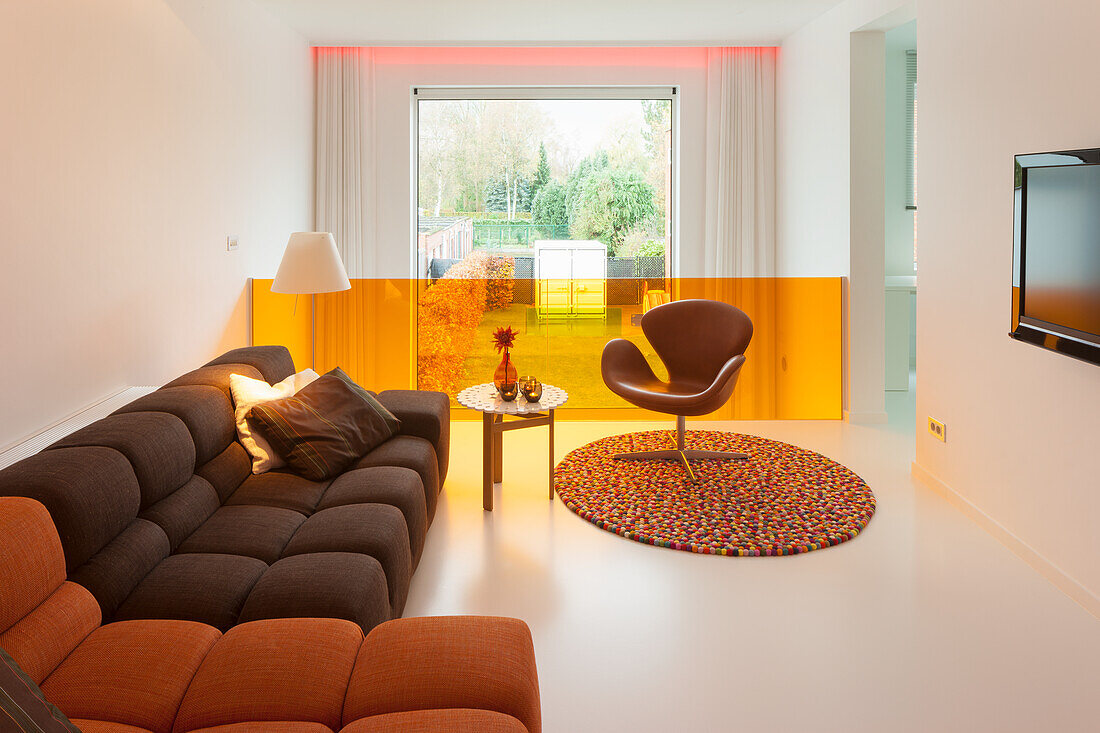 Modern eingerichtetes Wohnzimmer mit Farbakzenten und Designermöbeln