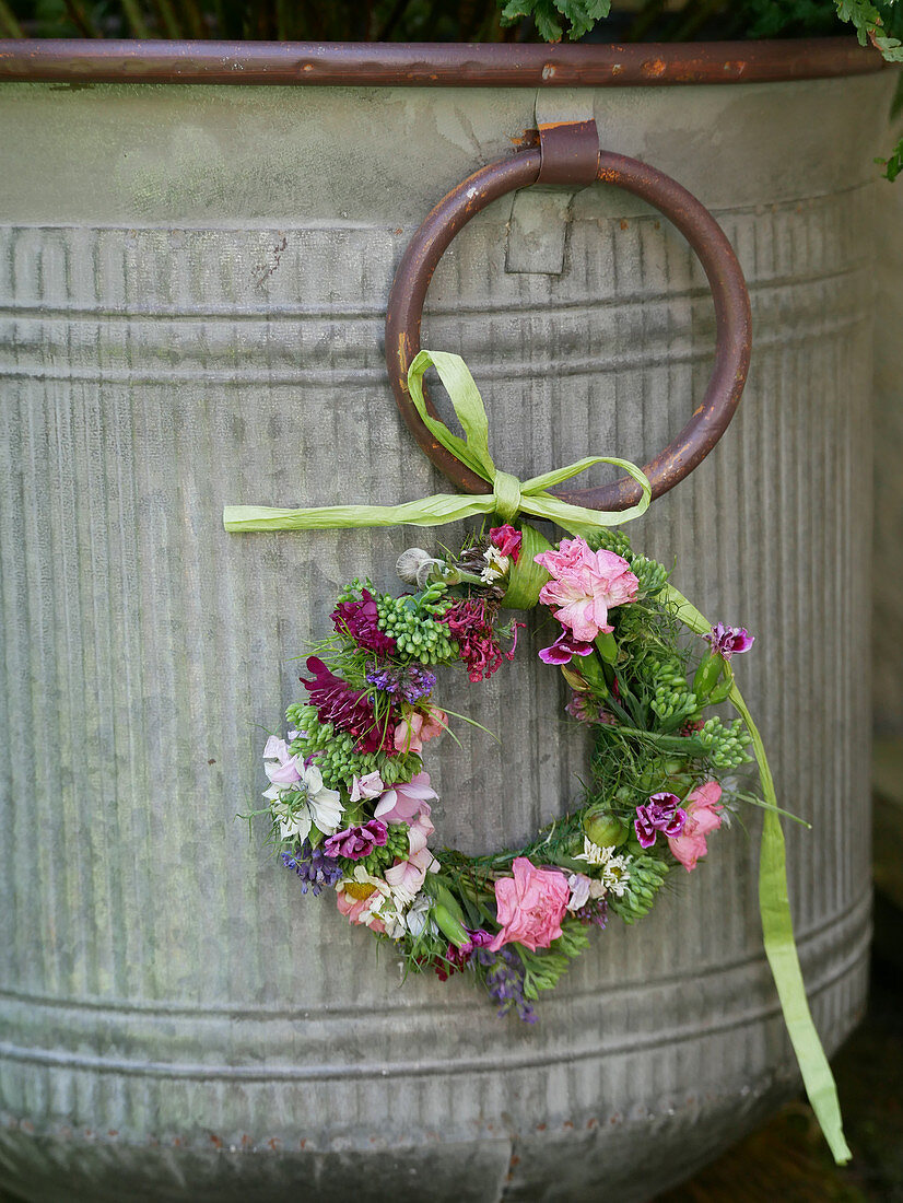 Small wreath of flowers on the zinc bucket
