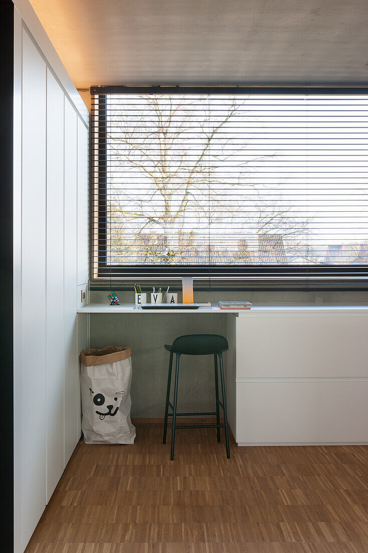 Minimalistischer Schreibtisch vor Fensterfront mit Jalousie