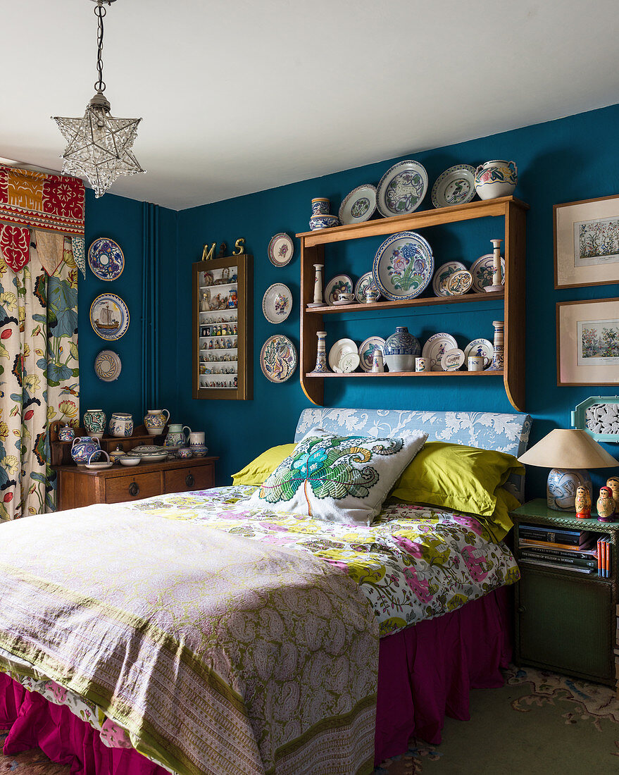 Collection of crockery on plate rack on blue bedroom wall