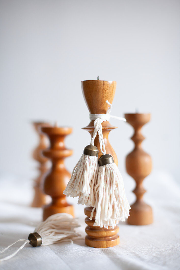 Selbstgemachte Quasten an gedrechselten Kerzenständern aus Holz