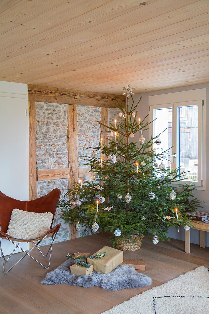 Schlicht geschmückter Weihnachtsbaum im ländlichen Wohnzimmer