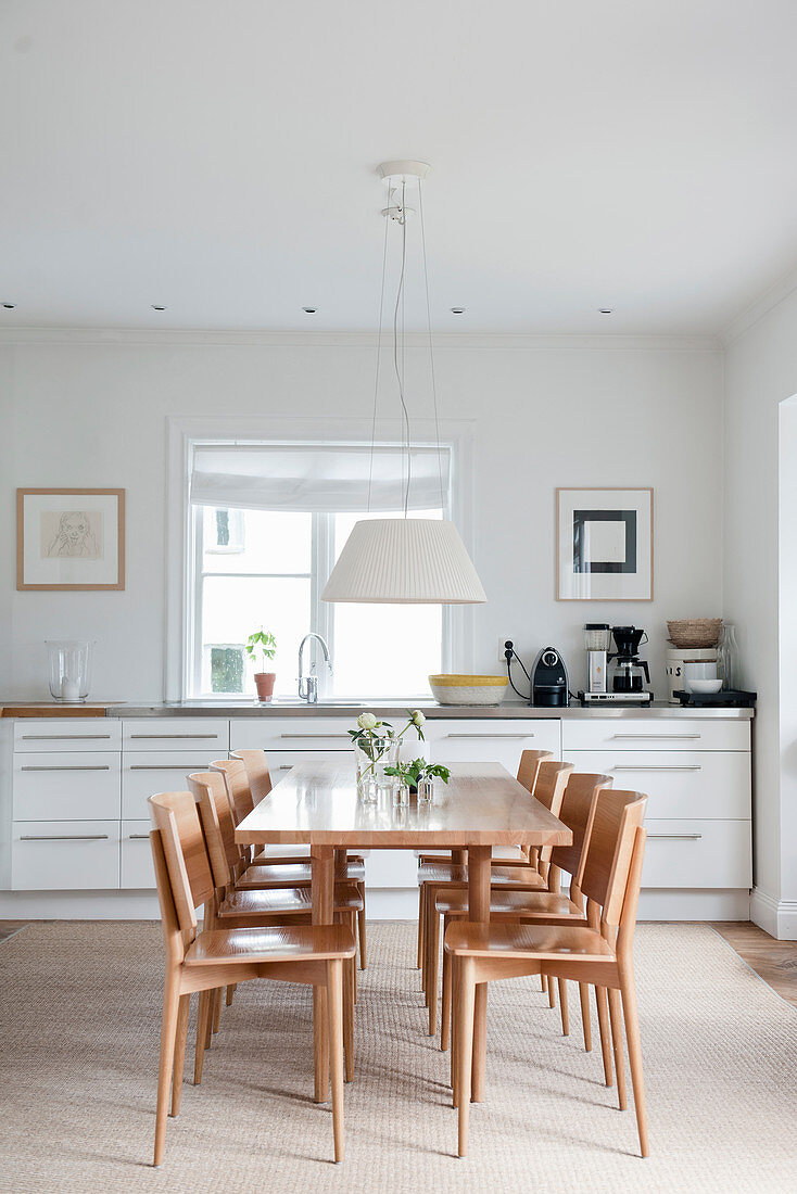 Pale wooden dining set in front of white kitchen counter
