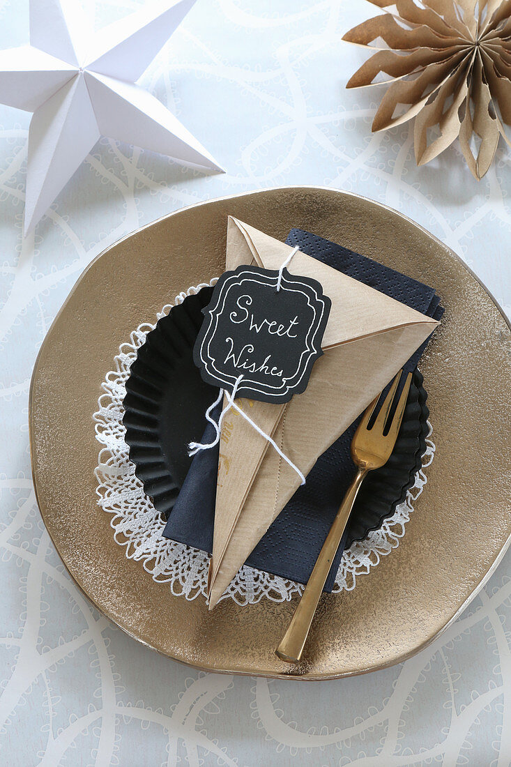 Handmade paper cone with motto on Christmas place setting with golden plate