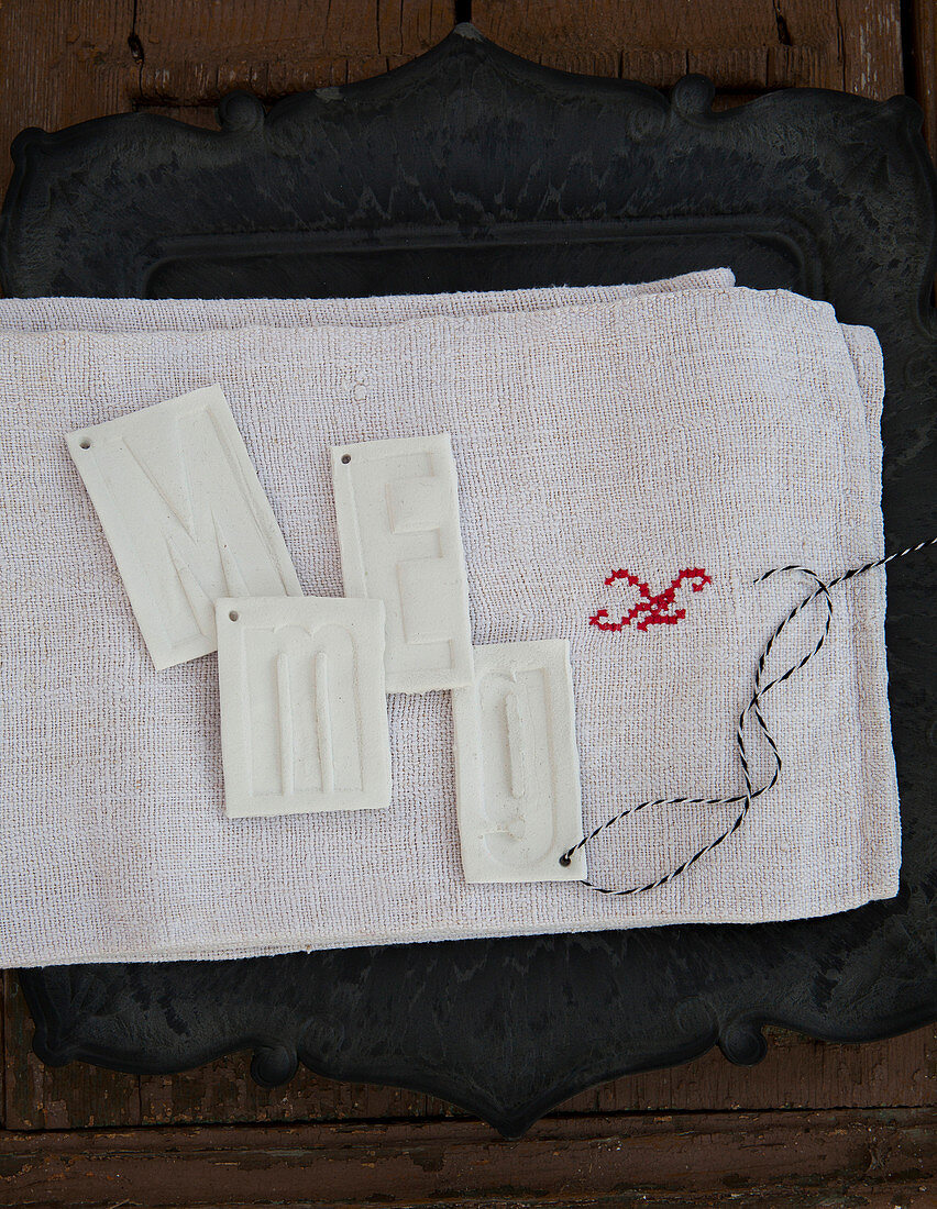 Modelling-clay pendants embossed with initials
