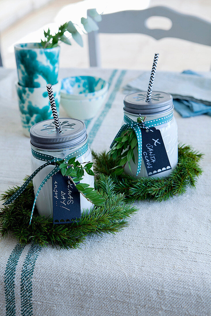 Drinks in jars with straws and screw-top lids, wreaths of pine and mottoes