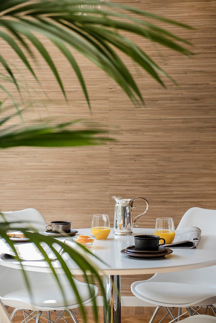 Blick durch Palmblätter auf gedeckten Frühstückstisch