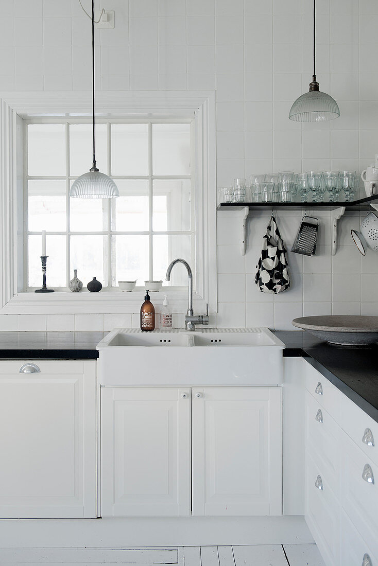 Spülstein in der Küche in Schwarz und Weiß mit Sprossenfenster