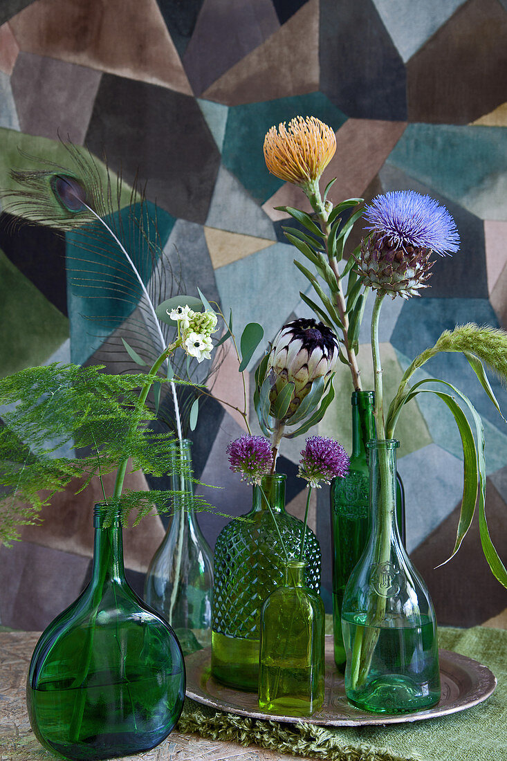 Artischockenblüte, Amaranth, Nadelkissen-Protea, Protea, Zierlauch, Milchstern und Zierspargel in Flaschen