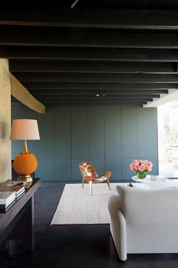 Blue-grey fitted cupboards in living room with black ceiling beams