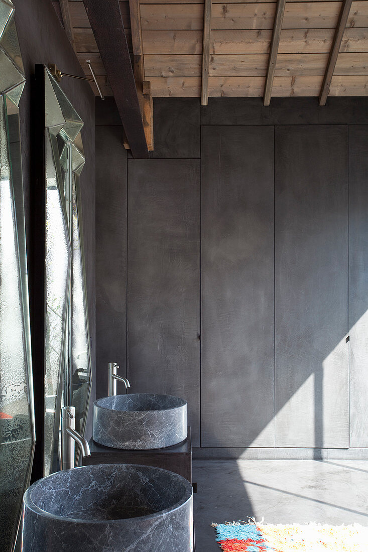 Round, stone sinks in bathroom with fitted cupboards