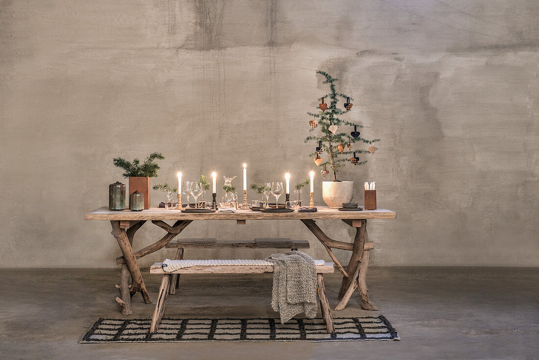 Weihnachtlich dekorierter, rustikaler Holztisch mit Gestell aus Ästen